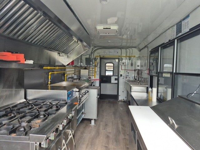 Inside the food trailer: stainless kitchen with stove and hood