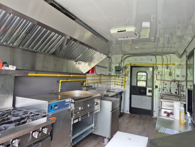 Inside the food trailer: flat-top griddle, fryer and prep area